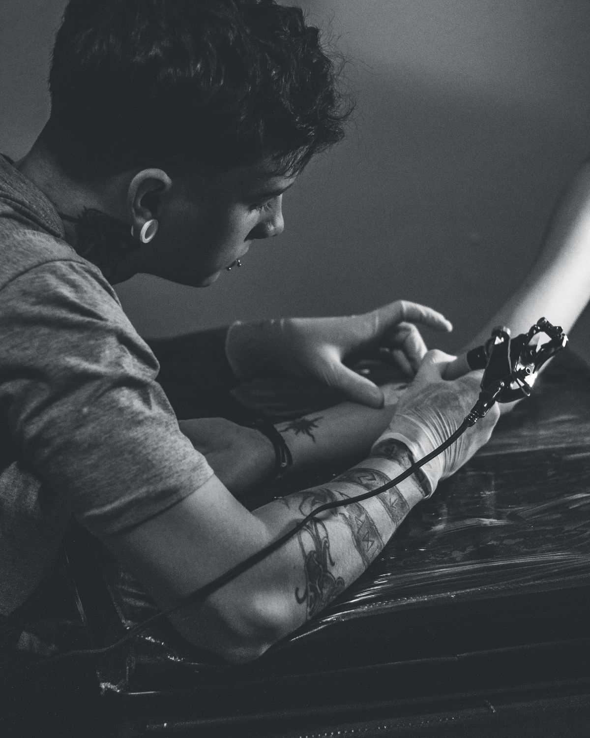 Tattoo artist working carefully on a client's arm